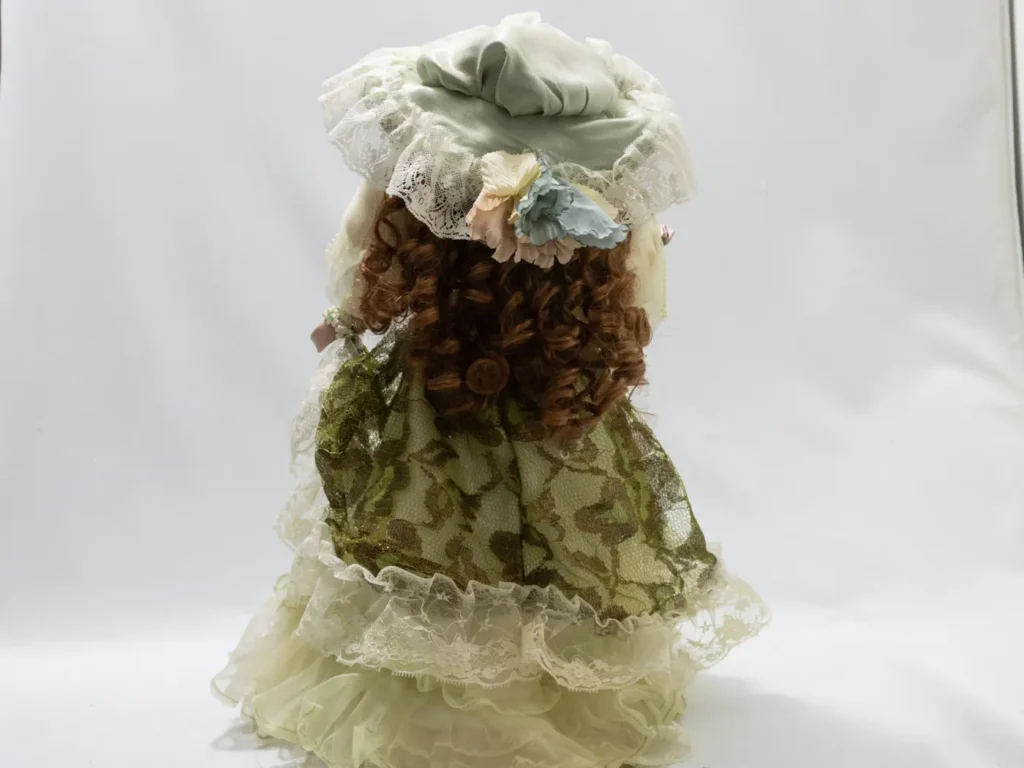 Grande poupée de porcelaine vintage à la robe verte satinée
