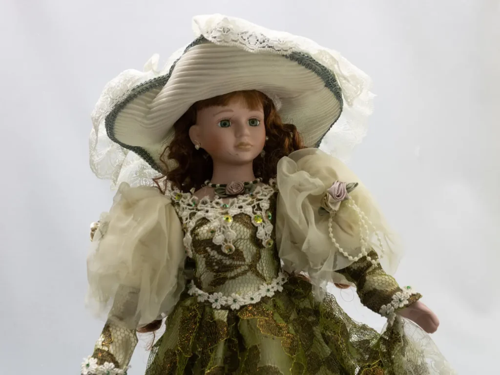 Grande poupée de porcelaine vintage à la robe verte satinée