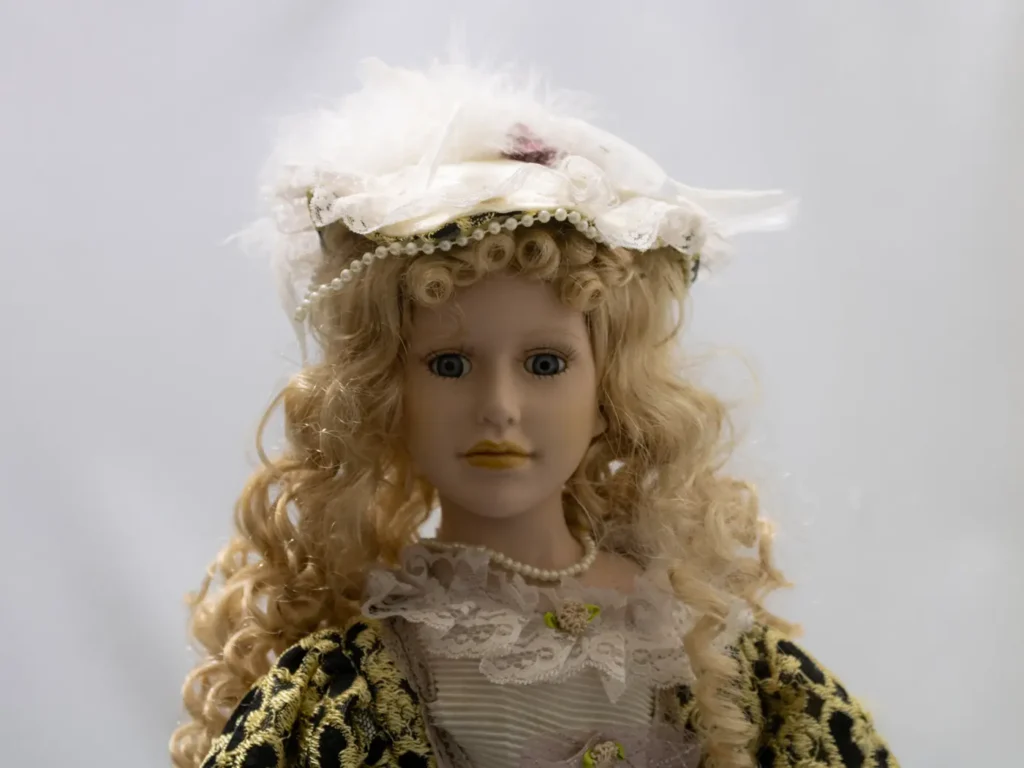 Poupée de porcelaine blonde ancienne avec robe bleue et dentelle