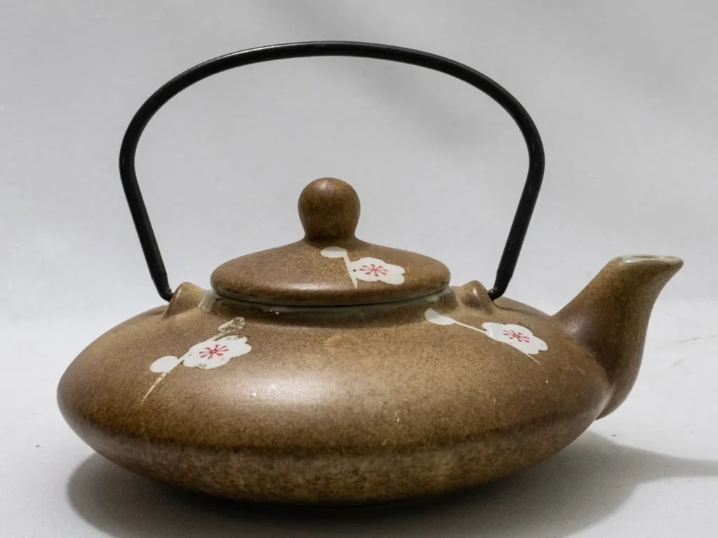 Théière ancienne en céramique avec motifs floraux multicolores